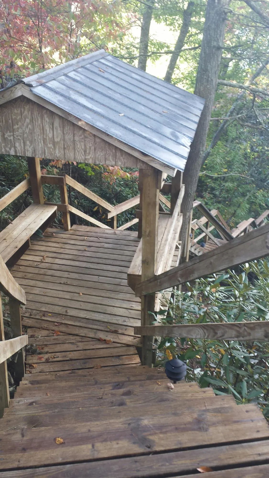 Metal roofed shelter over wooden steps on a wooded walkway — Skylight Repair & Installation work by our crew in West Newton